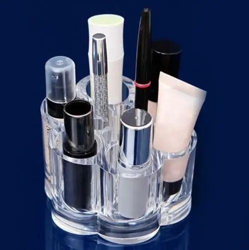Round acrylic vanity organizer filled with small cosmetics