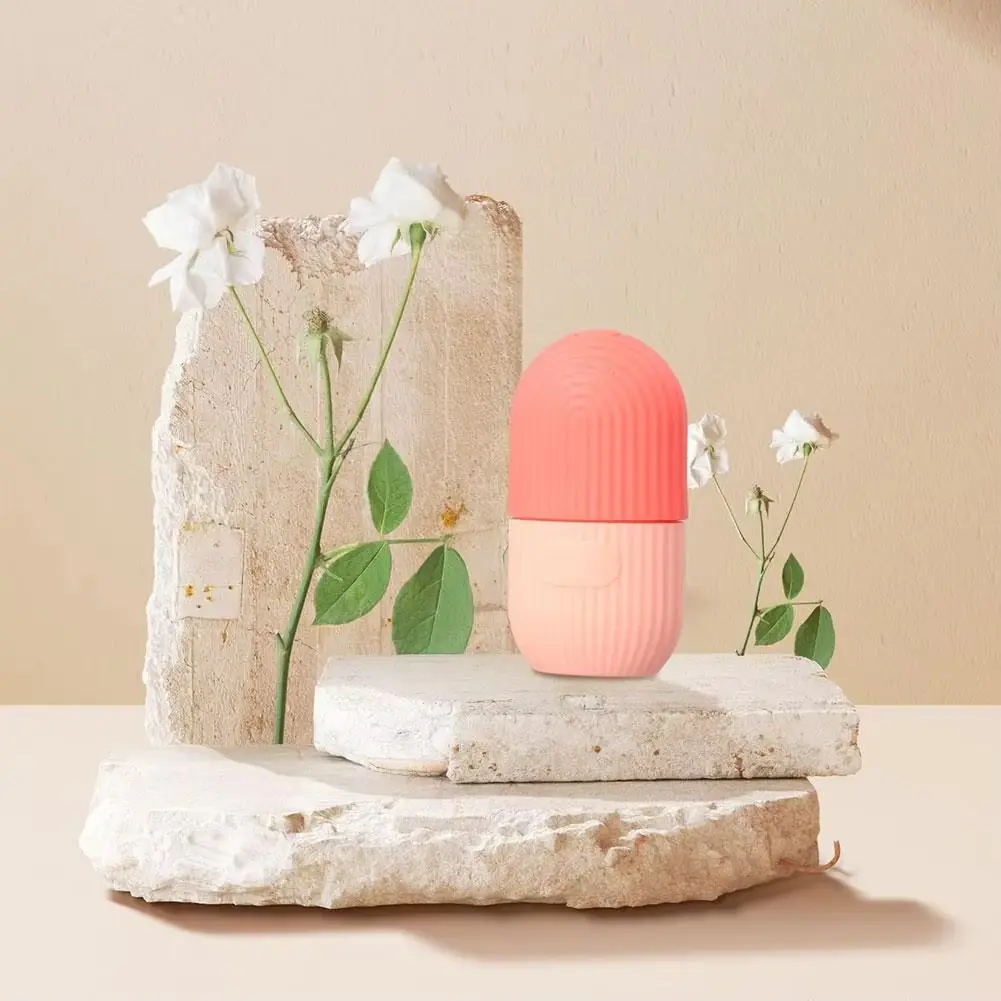 Coral reusable silicone face ice mold on a neutral background